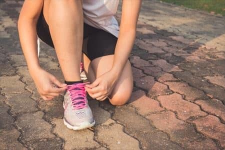 ランニングをする前にシューズのヒモを結んでいる様子
